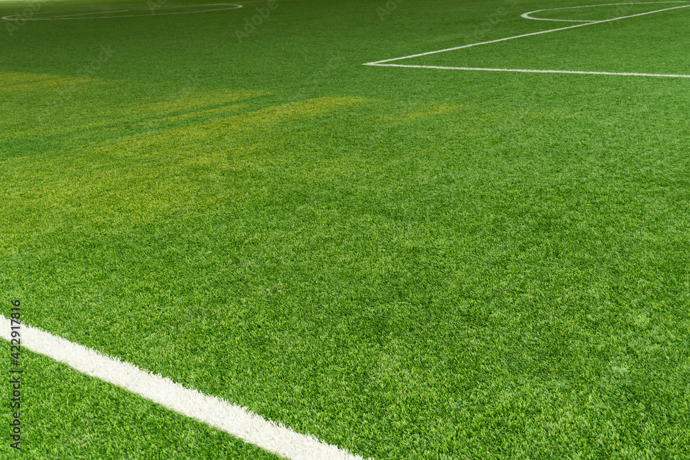 Obraz premium green artificial grass football field with white line