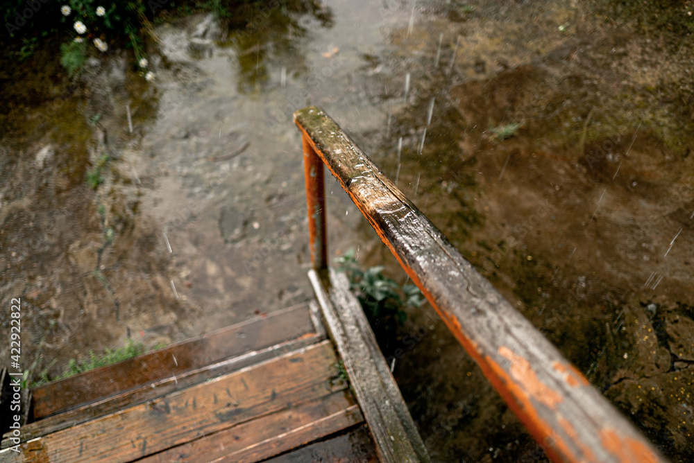 raindrops fall on the wooden porch