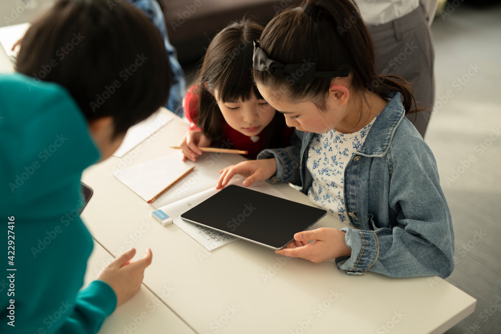 ICT in Education - Elementary School Students and Teacher Looking at Tablet PC ICT in Education - Elementary School Students and Teacher Looking at Tablet PC