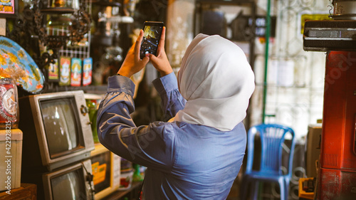 Asian women travel and visit antique shops wearing jilbab and analog camera