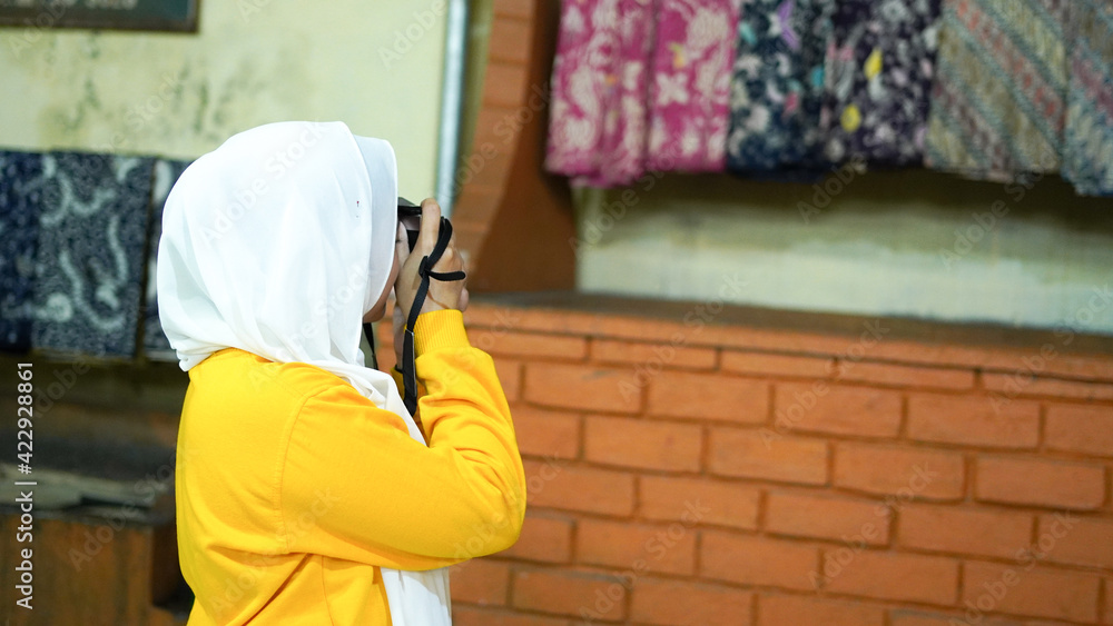 Asian women travel to see batik wearing jilbab and analog camera Asian women travel to see batik wearing jilbab and analog camera