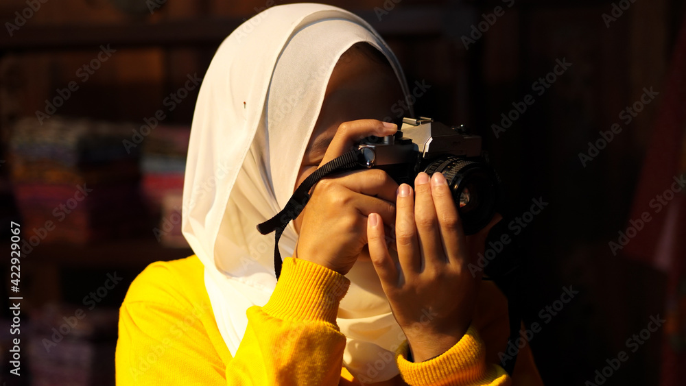 Fototapeta premium Asian women travel to see batik wearing jilbab and analog camera
