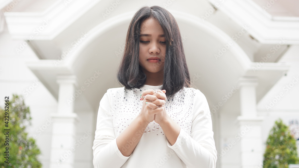 a Christian woman praying humbly in church a Christian woman praying humbly in church