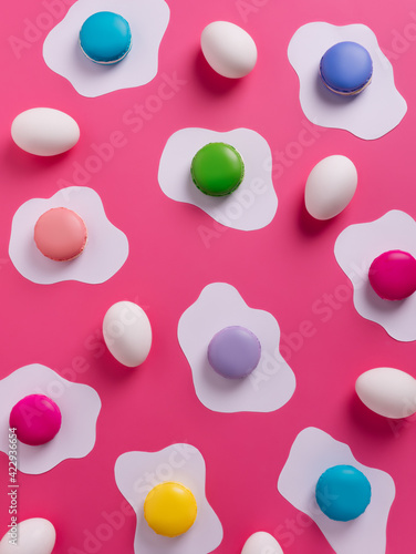 Pop art pattern with macarons colorful fried and fresh eggs on pink background. Creative food layout. Flat lay, top view.