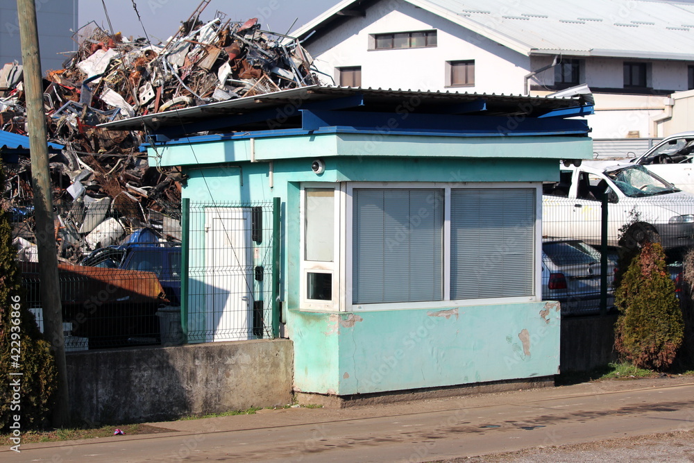 Old dilapidated light green guard house with closed window blinds and