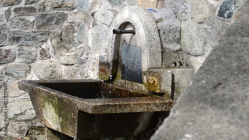 Clear and cold water flowing from metal pipe, fountain, waterplace, side view photo
