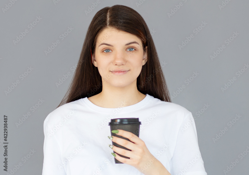 Photo of cheerful positive pretty sweet girlfriend holding mug of coffee smiling isolated over gray color background Photo of cheerful positive pretty sweet girlfriend holding mug of coffee smiling isolated over gray color background