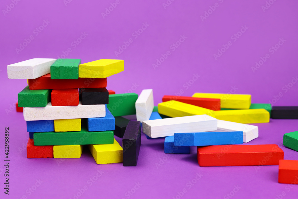 Tower game and scattered colored wooden blocks Tower game and scattered colored wooden blocks