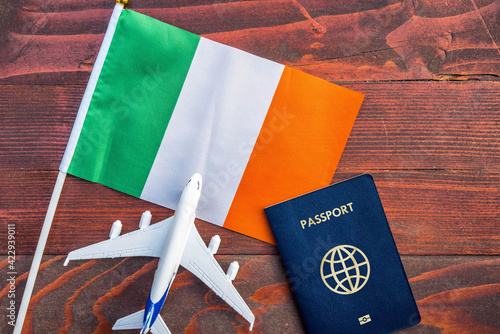Fotografie Flag of Ireland with passport and toy airplane on wooden background