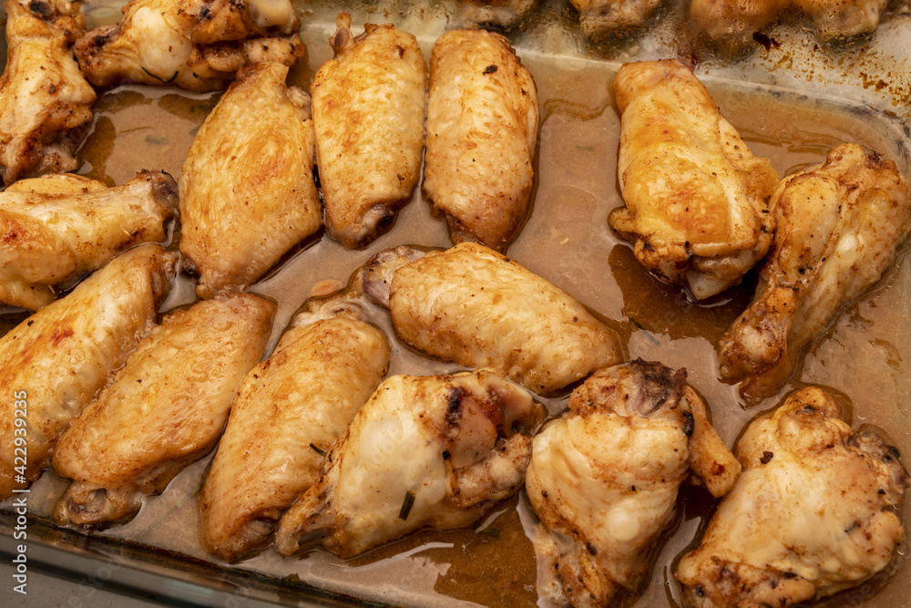 Home roasted chicken wings with honey sauce on a baking tray. Home roasted chicken wings with honey sauce on a baking tray.