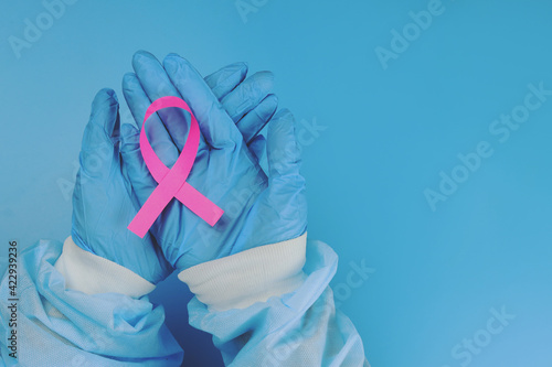 Pink ribbon in the doctor's hand, breast cancer struggle symbol