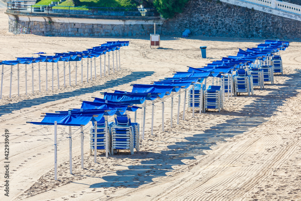 Empty beach, no person. No one on the beach, no tourists or quarantined travelers. With hammocks and blue umbrellas (Spain)