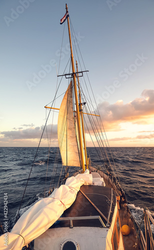 Sailing old schooner at sunset, travel and adventure concept. © MaciejBledowski
