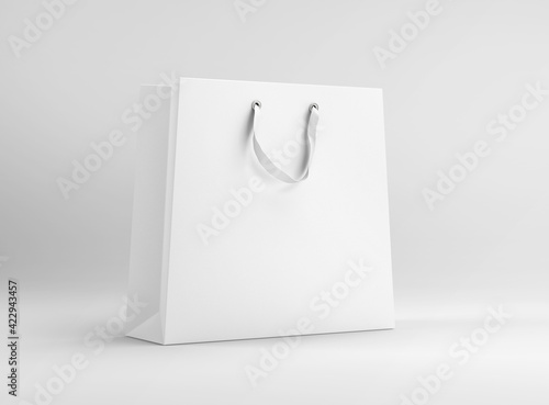 White plain paper shopping bag with ribbon handle on isolated background photo