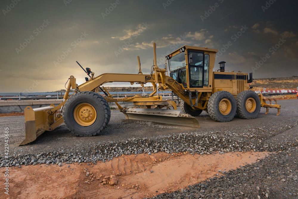 Excavator machine leveling the ground at a road construction site
