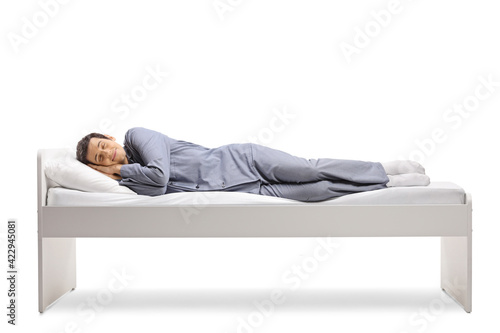 Full length shot of a man sleeping peacfully in a single bed photo