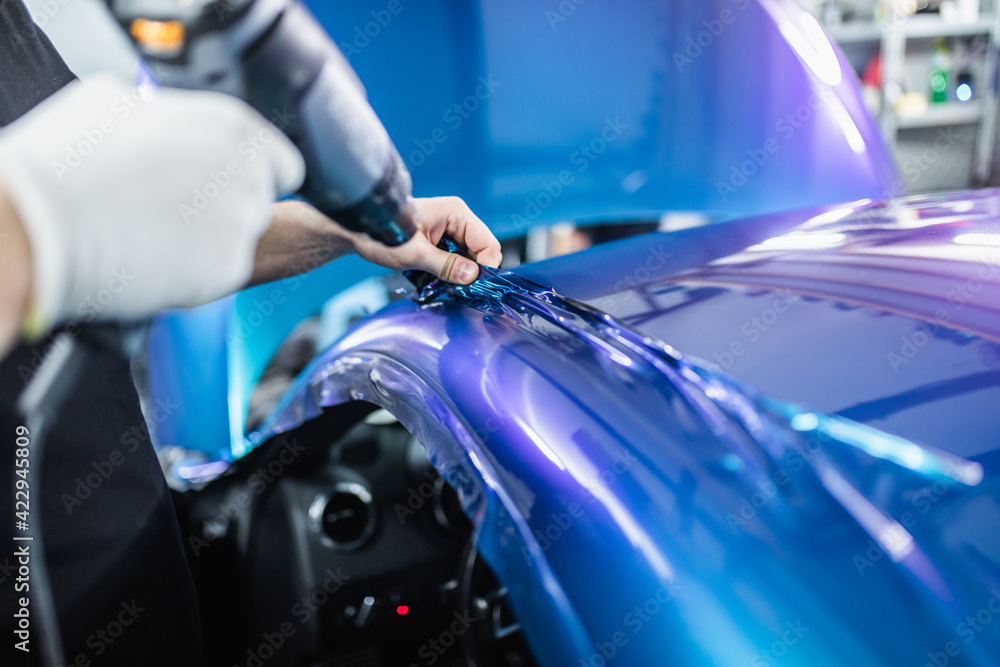Car wrapping specialist putting vinyl foil or film on car. Selective focus. Car wrapping specialist putting vinyl foil or film on car. Selective focus.