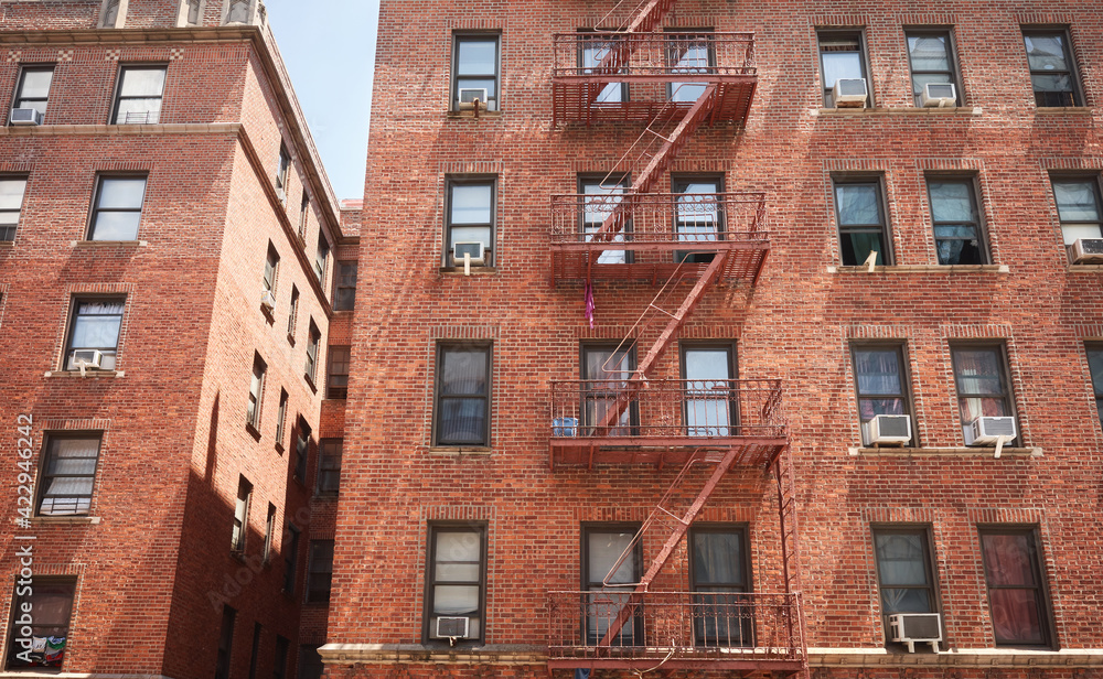 Old red brick building with fire escape, New York City, USA.