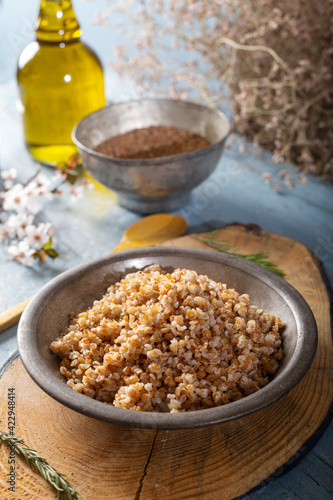 Einkorn, Triticum Monococcum, Siyez wheat bulgur.Bulgur pilaf made with siyez bulgur in plate on wooden background. © ozgur