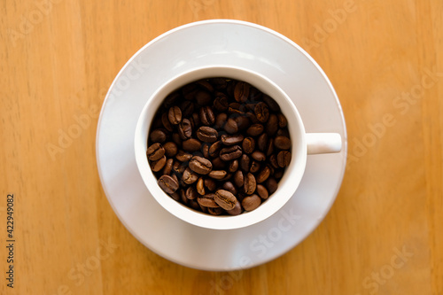 coffee beans in cup coffee on table wood background