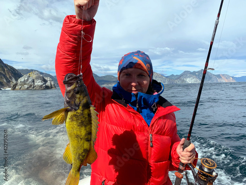 A girl on a sea fishing caught a huge perch