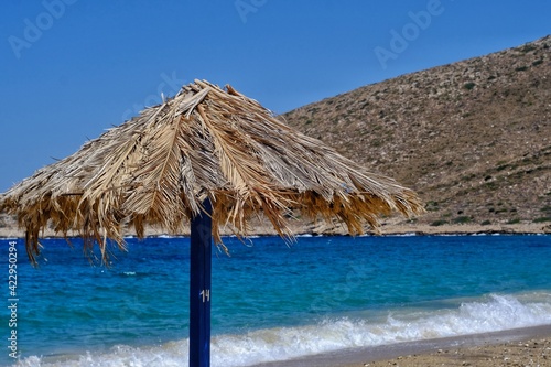 A beach umbrella in front of the aegean sea in Ios cyclades Greece 