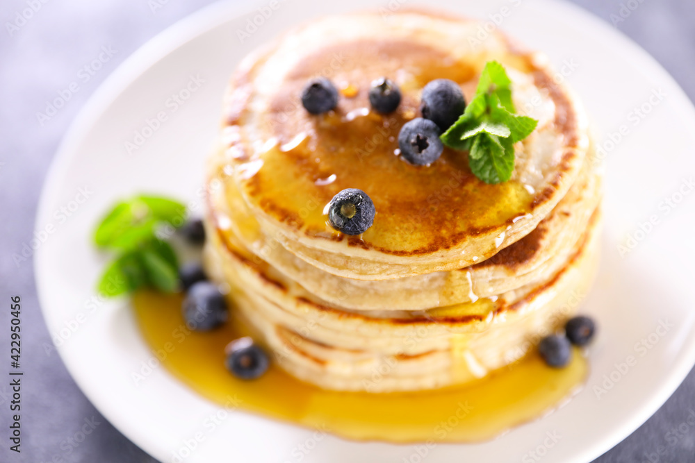stack of pancakes with blueberries and syrup