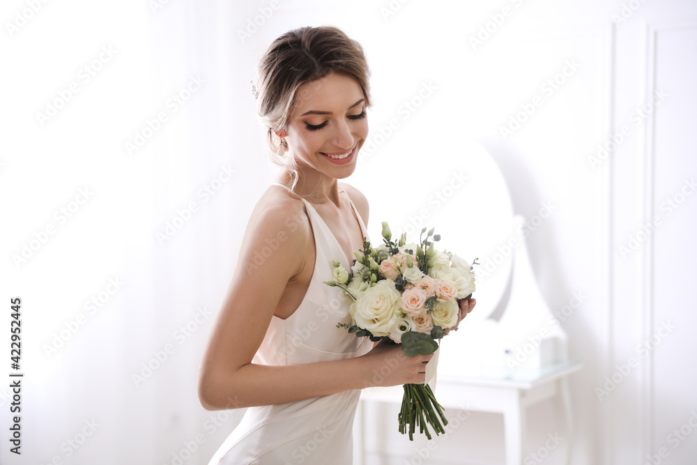 Bride in beautiful wedding dress with bouquet indoors Bride in beautiful wedding dress with bouquet indoors