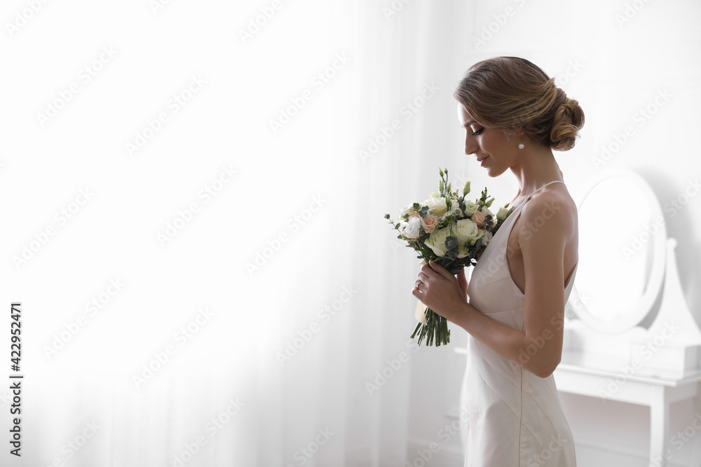 Bride in beautiful wedding dress with bouquet indoors. Space for text Bride in beautiful wedding dress with bouquet indoors. Space for text