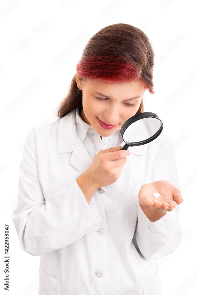 Young female doctor examining a pill though magnifying glass Young female doctor examining a pill though magnifying glass