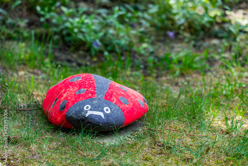 Handmade painted acrylic stone ladybug in garden