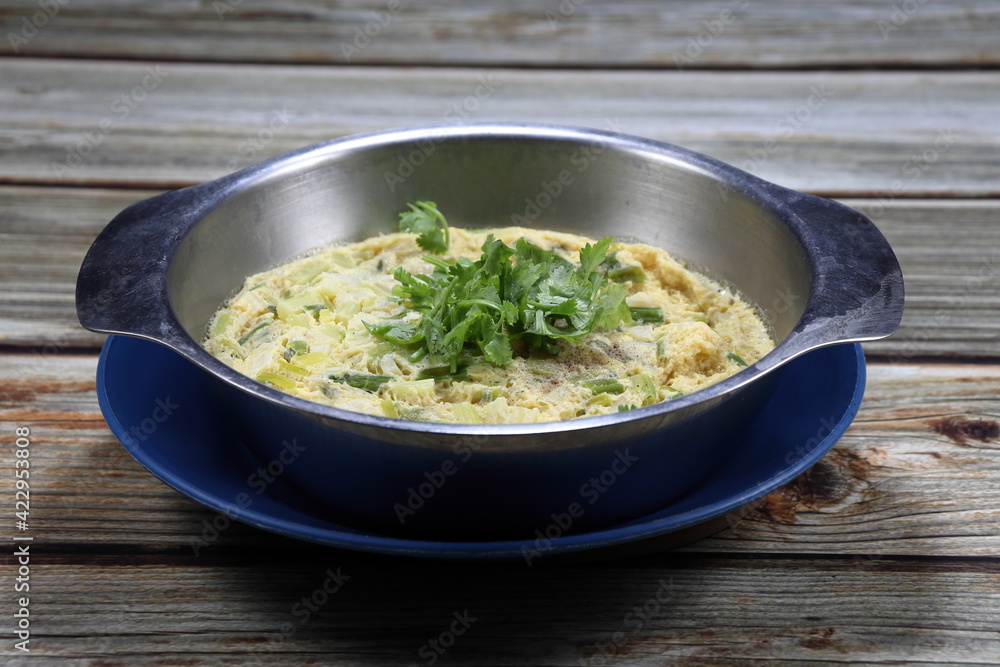Traditional Chinese steamed egg topping with fresh coriander serving in the stainless bowl. Famous breakfast menu in Asia. Traditional Chinese steamed egg topping with fresh coriander serving in the stainless bowl. Famous breakfast menu in Asia.