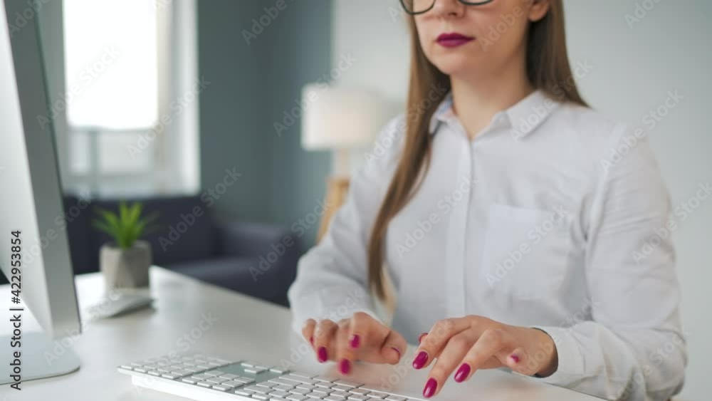 Woman with glasses typing on a computer keyboard. Concept of remote work. Woman with glasses typing on a computer keyboard. Concept of remote work.