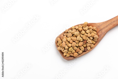 Dry raw organic chickpeas in a wooden spoon isolated on white background.