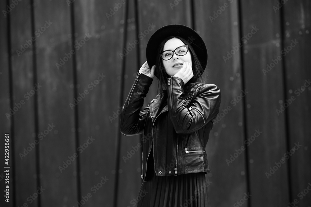 Beautiful russian girl dressed in black leather clothes and eyeglasses. Rock style european woman in urban background. Beautiful russian girl dressed in black leather clothes and eyeglasses. Rock style european woman in urban background.