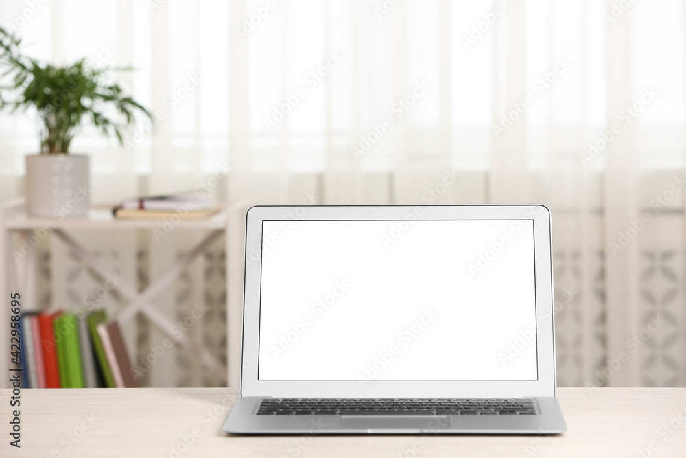 Modern laptop with blank screen on table at home Modern laptop with blank screen on table at home