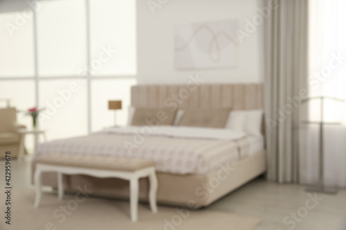 Blurred view of stylish hotel bedroom interior with modern furniture