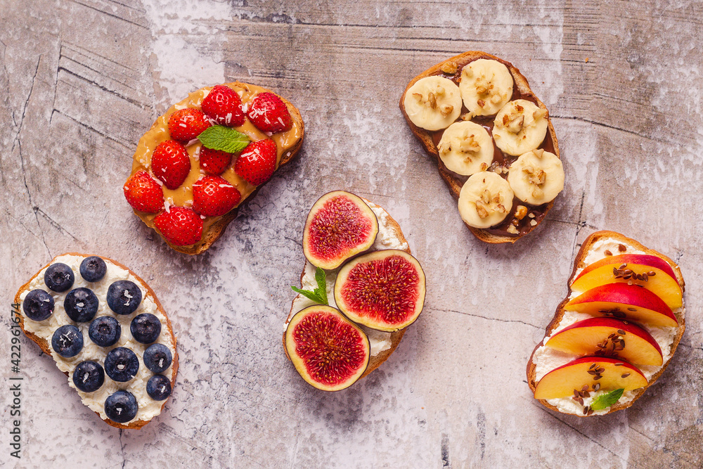 Homemade summer toast with cream cheese, nut butter and fruits and berries Homemade summer toast with cream cheese, nut butter and fruits and berries