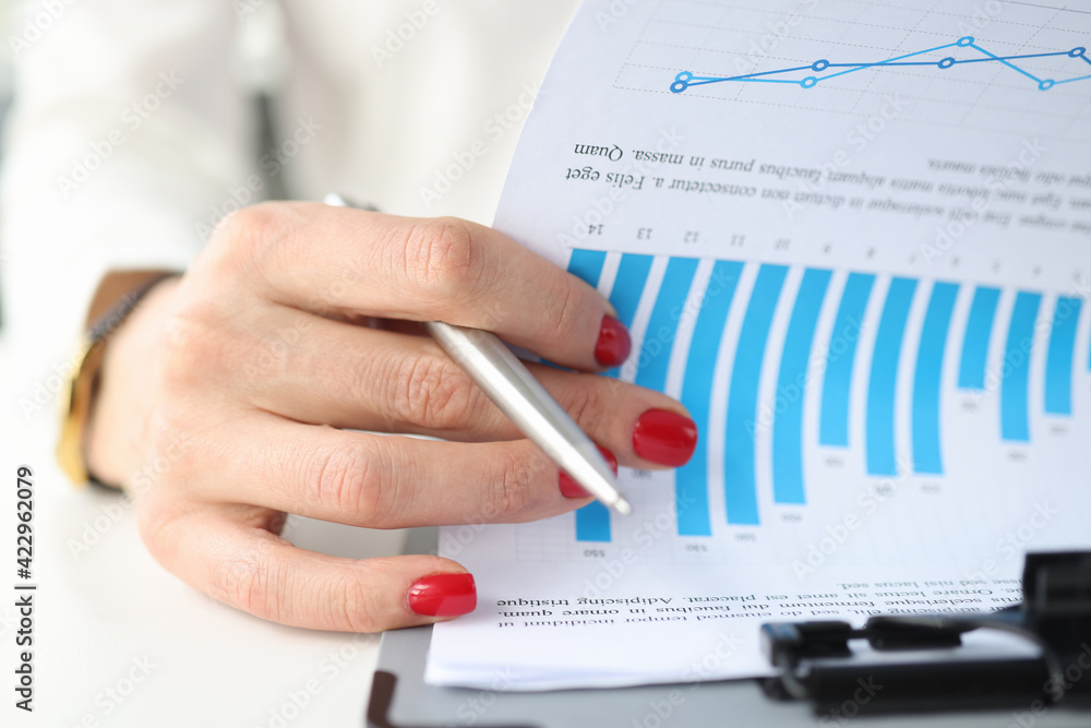 Female hand leafing documents with graphs on clipboard closeup Female hand leafing documents with graphs on clipboard closeup