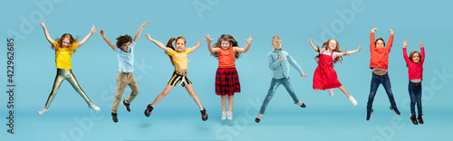 Little and happy kids gesturing isolated on blue studio background. Human emotions, facial expression concept