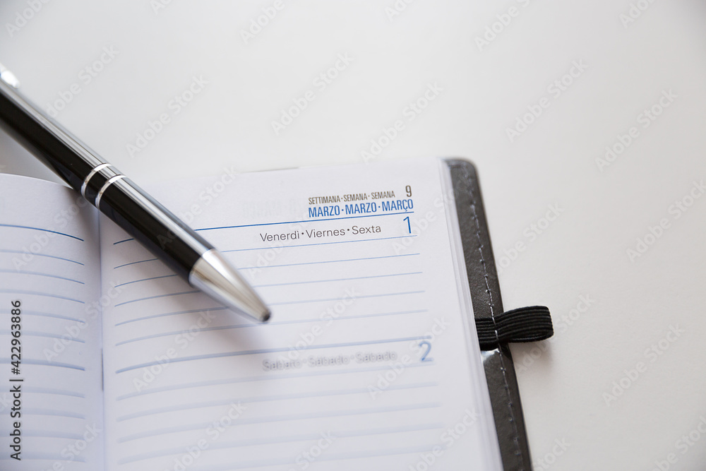 Agenda settimanale con penna su tavolo bianco Agenda settimanale con penna su tavolo bianco