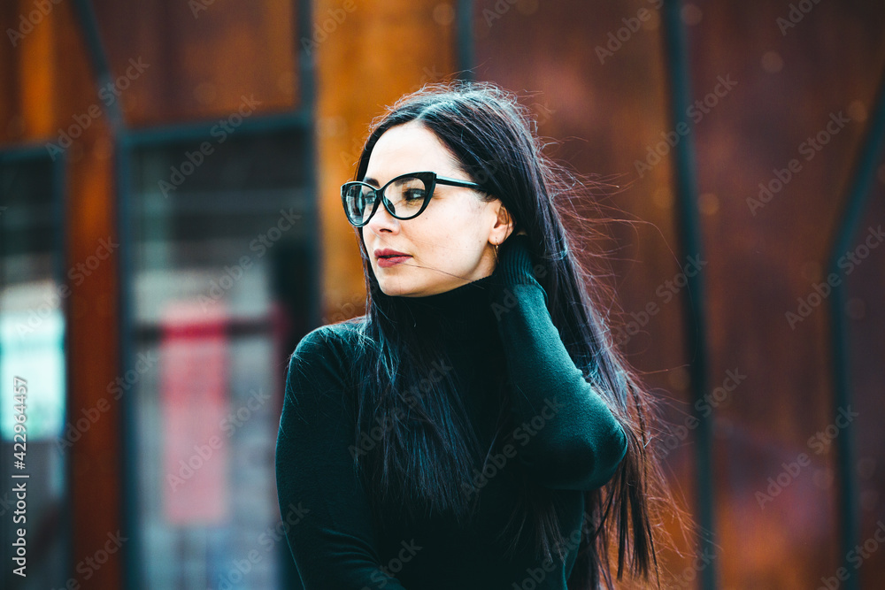 Beauty sexy fashion model woman portrait wearing eye glasses. Elegant woman looking at camera in the black dress with glasses