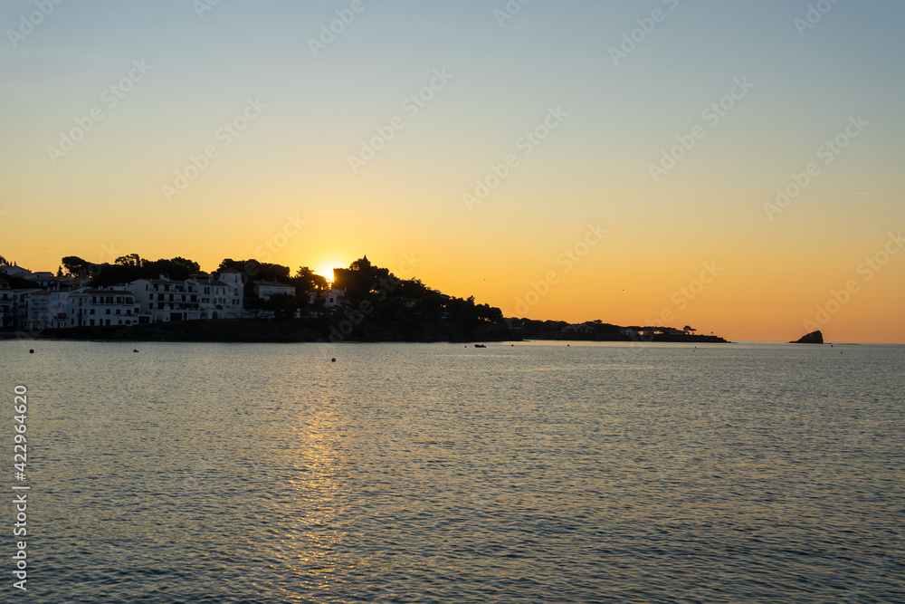 Marvelous sunrise at beautiful costal town Cadaques at Catalonia, Spain. Cosy houses on the Mediterranean sea light by the rising sun with the soft warm light.  Serenity and off season vacation. 