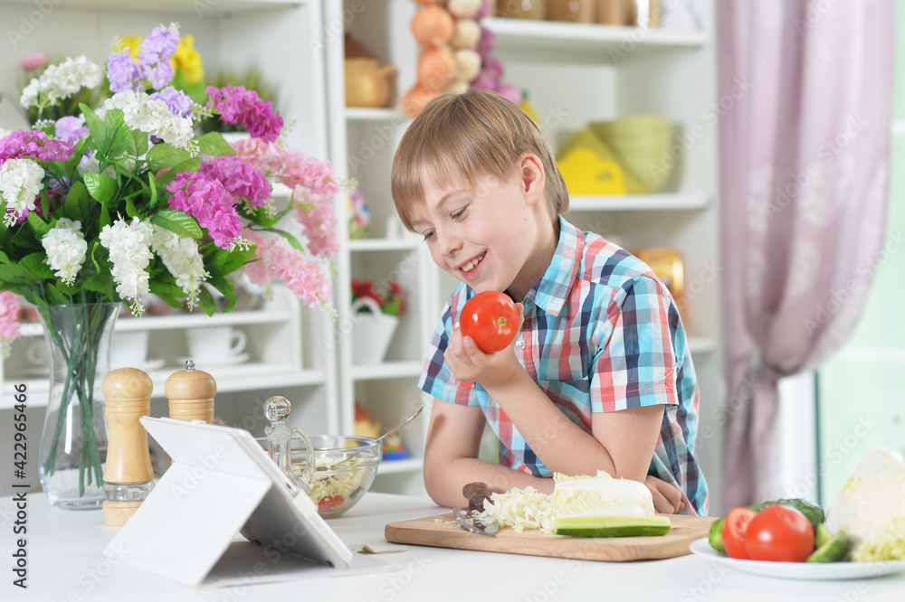 Cute little boy making dinner