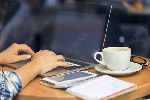 Female hands typing on pc. Unrecognizable women Working In A Cafe. Freelance work. Girl browsing the internet, chatting, blogging.