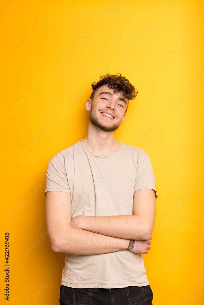 Junger Mann im T-Shirt vor einem gelben Hintergrund Junger Mann im T-Shirt vor einem gelben Hintergrund