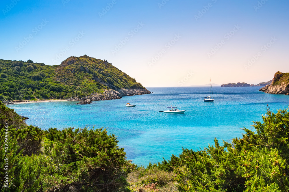 Boats in bay near Porto Timoni beach on Corfu island in Greece. Beautiful view of greek coast with green mountains, clear sea water and Pirate bay. Famous destination for summer vacation