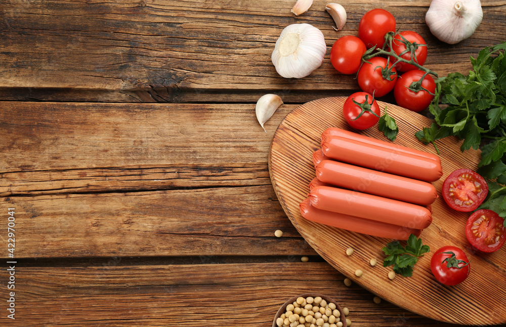 Fresh raw vegetarian sausages, soybeans and vegetable on wooden table, flat lay. Space for text Fresh raw vegetarian sausages, soybeans and vegetable on wooden table, flat lay. Space for text