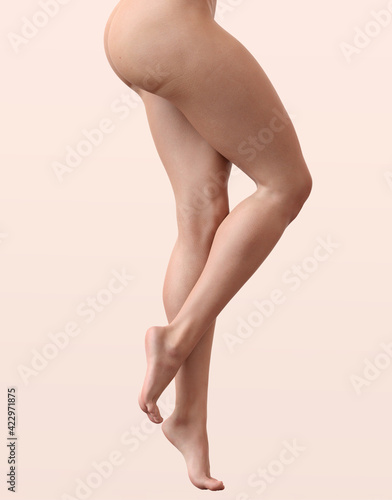 Female legs. Beige background. Spa beauty concept. © igor_shmel