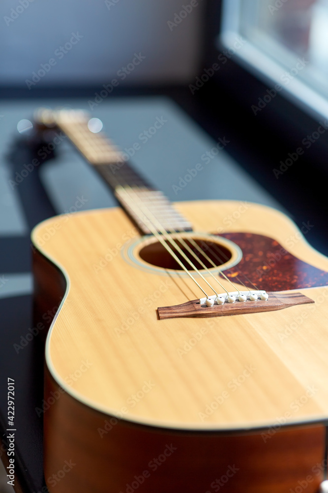 Fototapeta premium close up of acoustic guitar on window sill